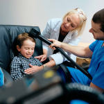 Paediatrician Doctor Doing Brain Treatment To Autistic Child In Clinic