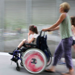 Disabled child in a wheelchair on a city street