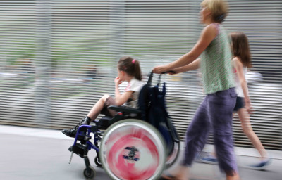 Disabled child in a wheelchair on a city street