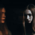 Young sad woman with schizophrenia hearing voices in her head