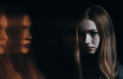 Young sad woman with schizophrenia hearing voices in her head