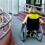 adult woman on wheelchair entering the building