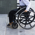 woman in wheelchair in front of inaccessible building