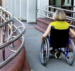 woman in wheelchair entering the building