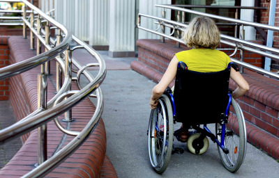 woman in wheelchair entering the building