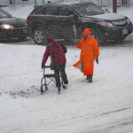 disabled woman walking with helper under snow