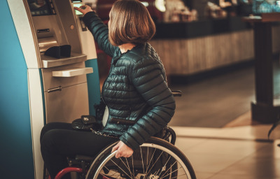 Woman in wheelchair using ATM