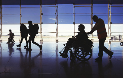 silhouette of man in wheelchair at airport