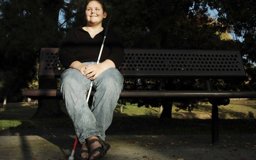 a blind woman sitting in the park