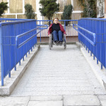 women in wheelchair leaving a building