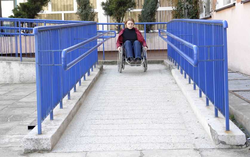 women in wheelchair leaving a building