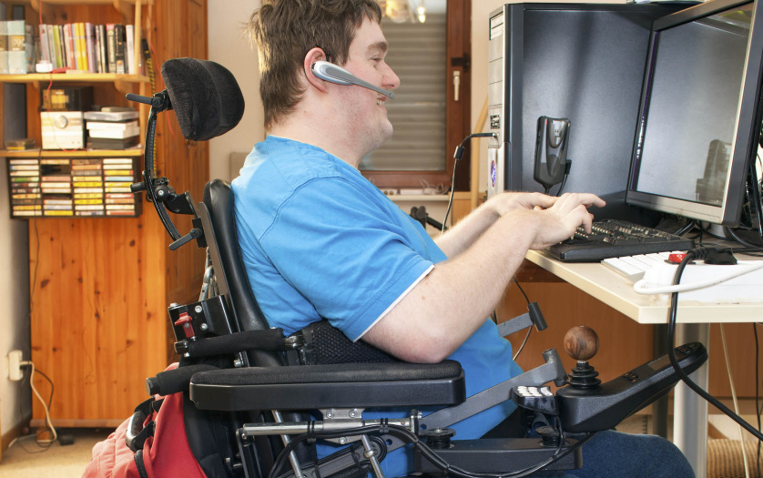 a man in wheelchair using computer