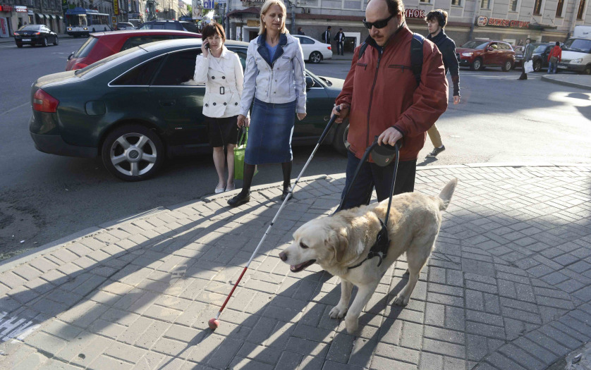 a blind person walking in the street
