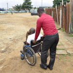 View of a person promoting the integration and displacement of a person in wheelchair in order to ease his travel