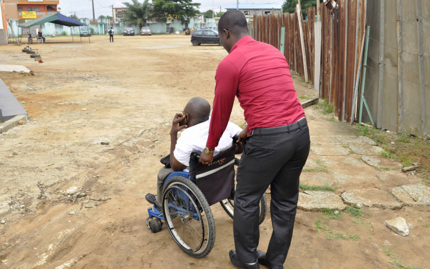 View of a person promoting the integration and displacement of a person in wheelchair in order to ease his travel