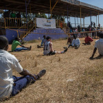 Students sit on the grass during an I'mPOSSIBLE activity in Malawi