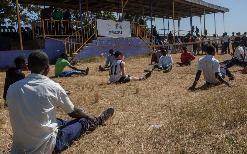 Students sit on the grass during an I'mPOSSIBLE activity in Malawi