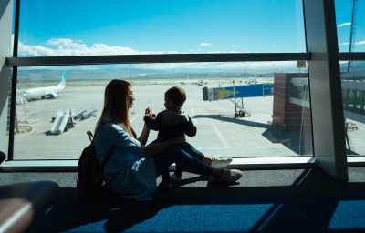 Little boy and his mother sitting in an airport