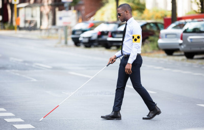 Young African Blind Man Wearing Armband Walking With Stick Crossing Road