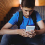 boy using mobile phone on staircase