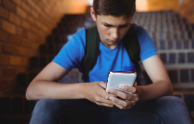 boy using mobile phone on staircase