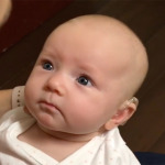 baby girl with hearing disability looking at mom