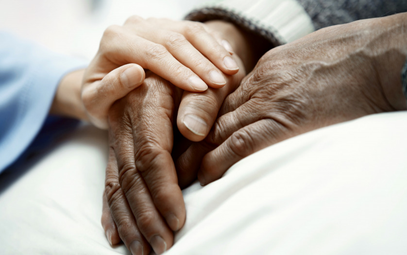 Hand of woman touching senior man in hospital