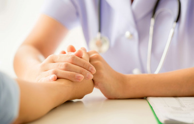 Female doctor consulting patient at the desk in hospital