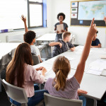 High School Students Raising Hands To Answer Question