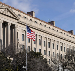Exterior of Washington D.C, Justice department building with American flag in foreground, U.S.A.