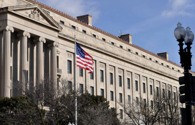 Exterior of Washington D.C, Justice department building with American flag in foreground, U.S.A.