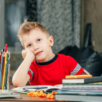boy daydreaming. He is tired homework.