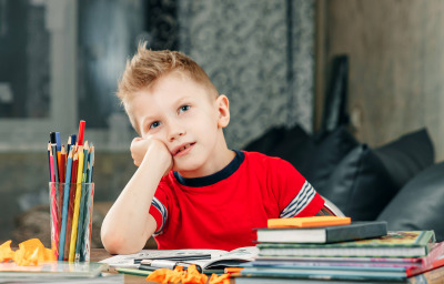 boy daydreaming. He is tired homework.