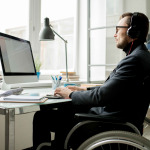 man in wheelchair working in the office