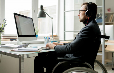 man in wheelchair working in the office