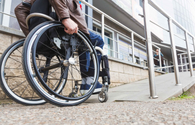 Man in a wheelchair use a wheelchair ramp.