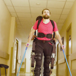 Young disable man in the robotic exoskeleton