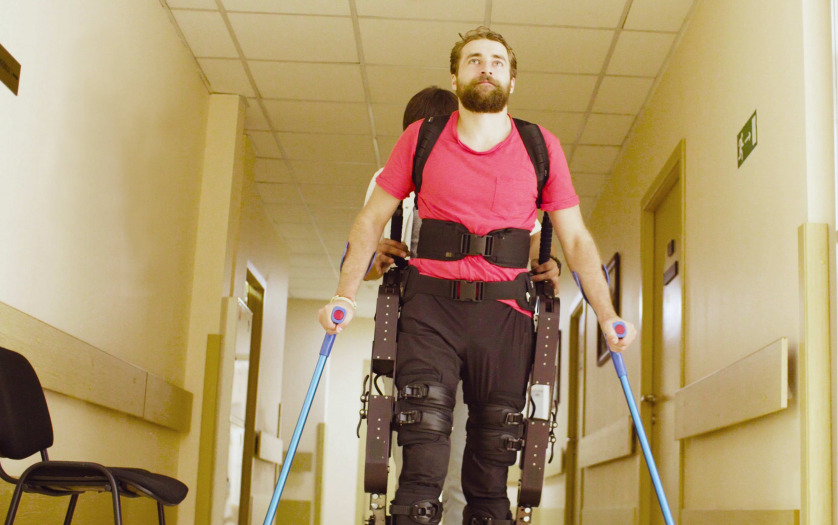 Young disable man in the robotic exoskeleton