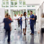 Staff In Busy Lobby Area of Modern Hospital