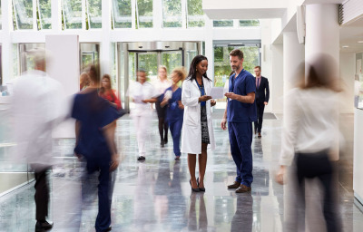 Staff In Busy Lobby Area of Modern Hospital