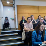 A wheelchair user at the top of steps in a lecture theatre
