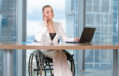 Young business woman in wheelchair working in office