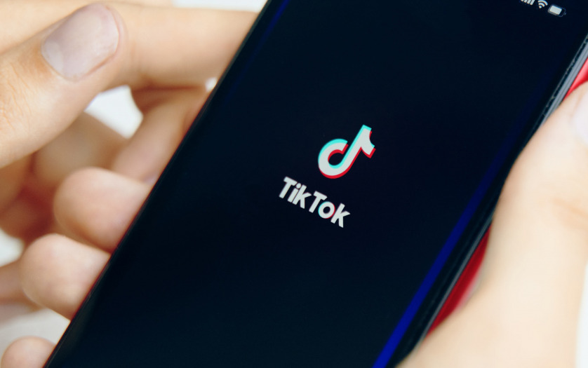 Phone in hand. tik tok application icon on phone