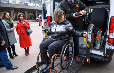 a woman in wheelchair getting off from an accessible taxi
