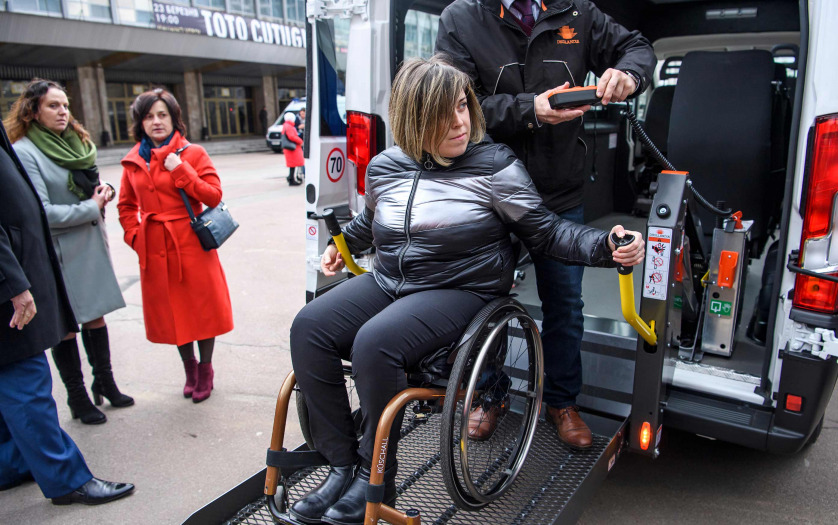 a woman in wheelchair getting off from an accessible taxi