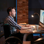 Side view of disabled businessman working in office