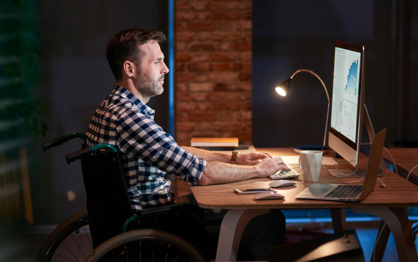 Side view of disabled businessman working in office