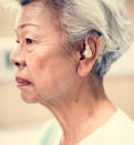 An elderly woman with hearing aid