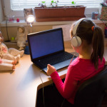 Girl in headphones using laptop