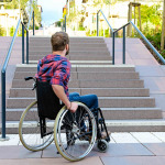 student in wheelchair in front of stairs